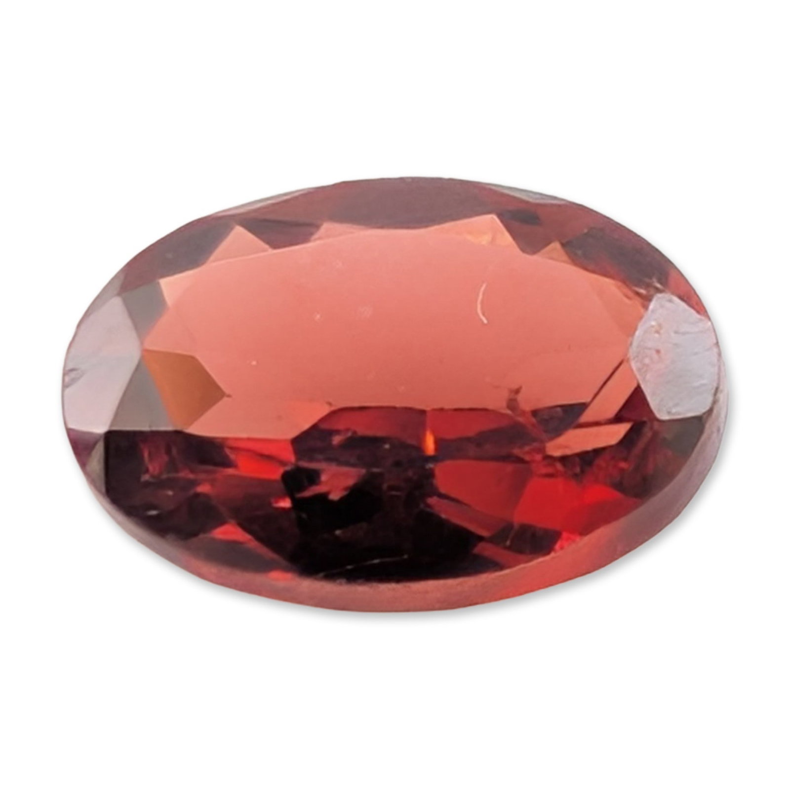 Oval Faceted Red Garnet Gemstone: Single loose red gemstone in an oval faceted cut. The stone appears to be a variety of garnet, featuring a deep brownish-red body color with bright red flashes under direct light. Based on visual