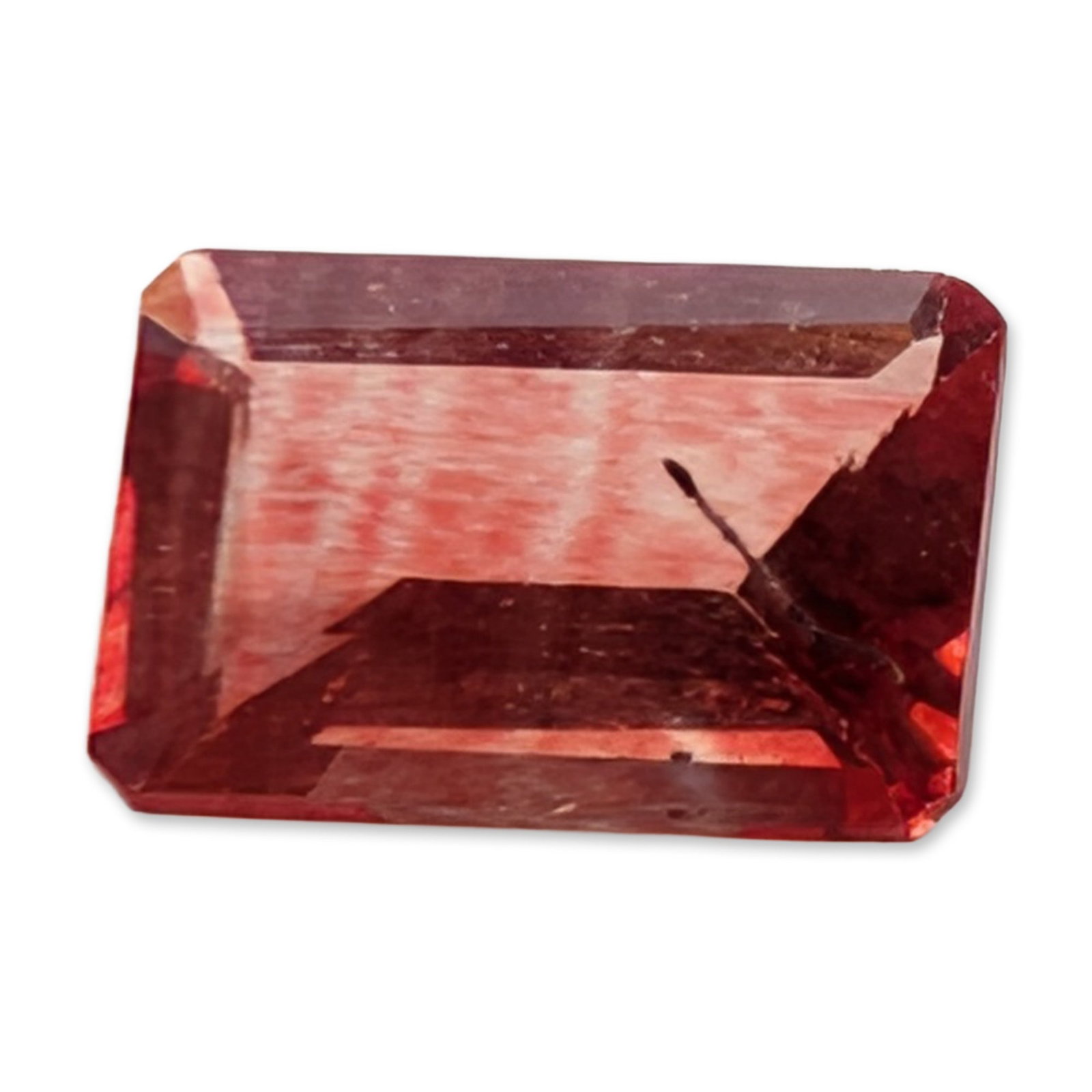 Oregon Sunstone Rectangular Emerald Cut Gemstone: Rectangular emerald-cut loose sunstone gemstone. The stone displays a saturated reddish-orange to strawberry-red hue with characteristic dense, fine, parallel reddish silk inclusions creating an inter