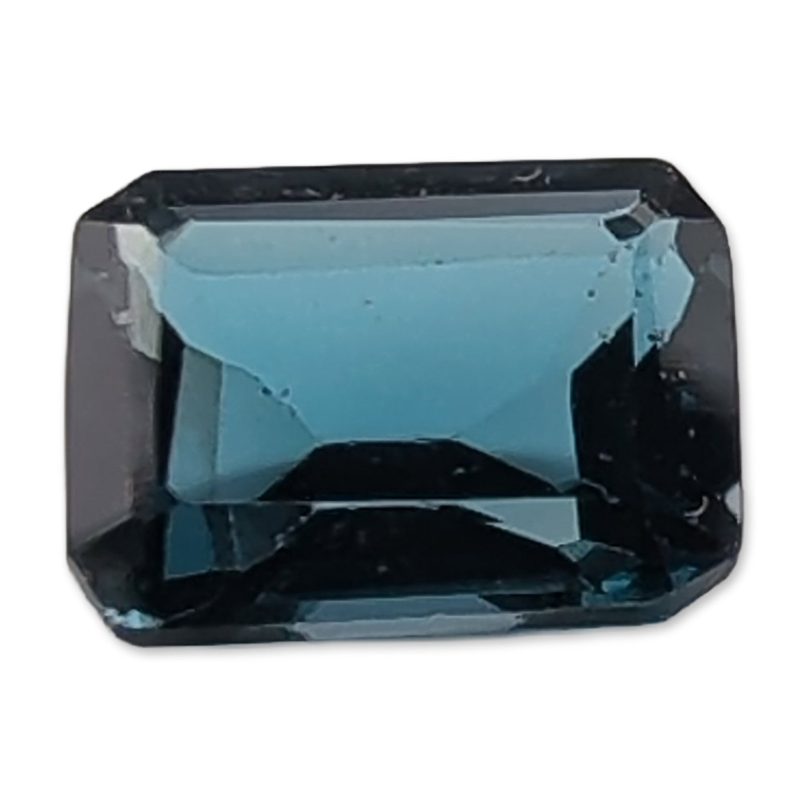 London Blue Topaz Emerald Cut Topaz Gemstone: Loose faceted topaz gemstone. The stone features a rectangular step cut, commonly known as an emerald cut, with clipped corners. It displays a deep teal blue color with high saturation. The clarity ap