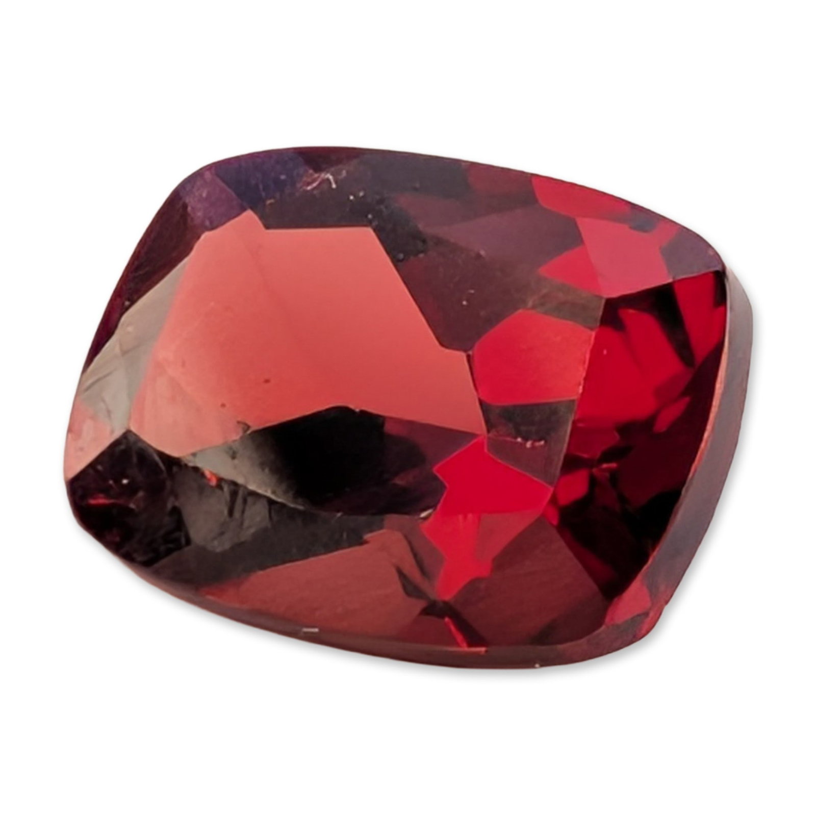 Loose Cushion Cut Red Gemstone: Loose faceted red gemstone in a cushion cut, appearing to be a member of the garnet group or a red spinel. The stone features a deep saturated red color with secondary pinkish-purple and dark crimson 