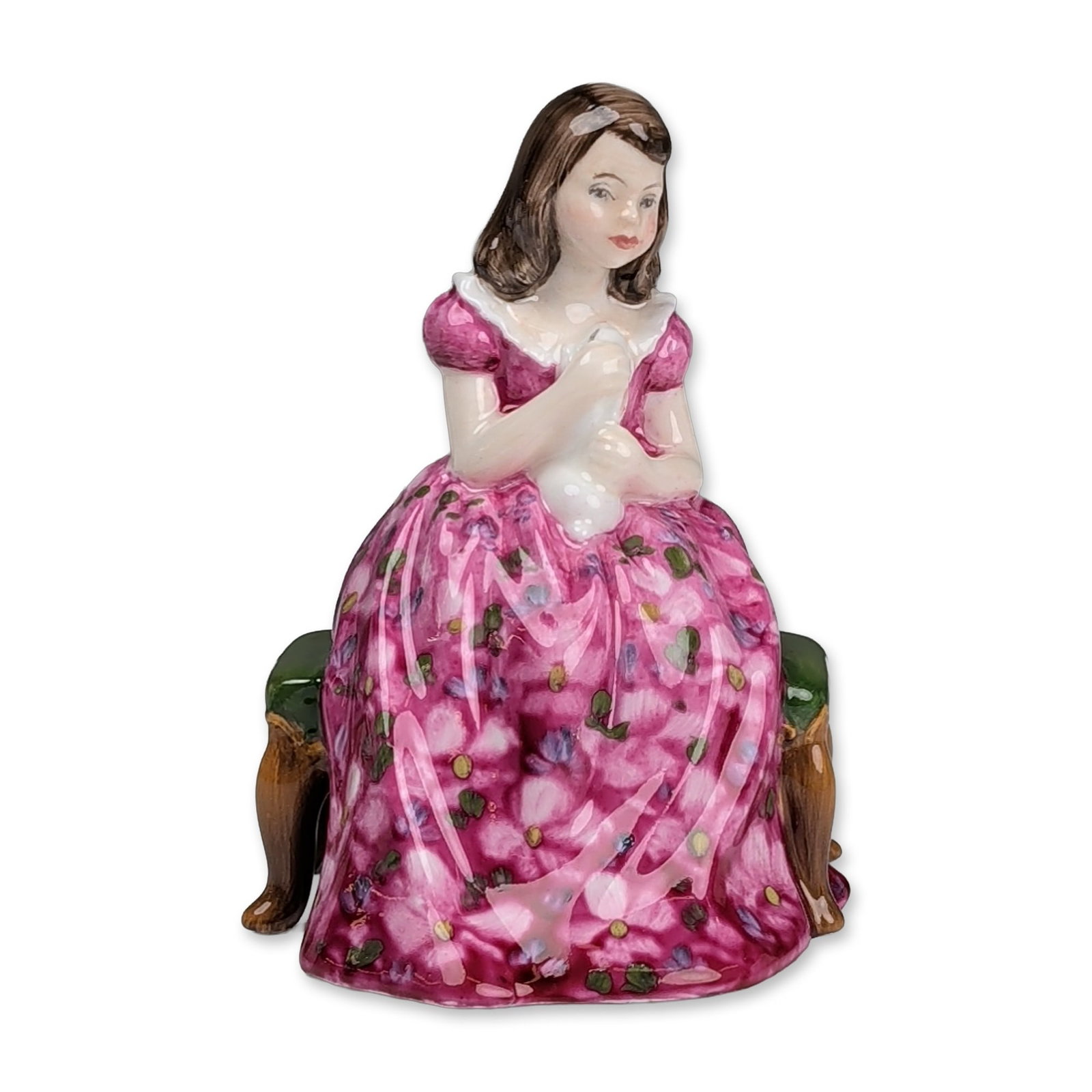 Royal Doulton Prototype Colorway Figurine, Affection HN2236: The hand-painted figure depicts a young woman with brown hair and a white ruff collar, seated on a green upholstered bench with brown cabriole legs. She wears a voluminous pink crinoline dress decorat