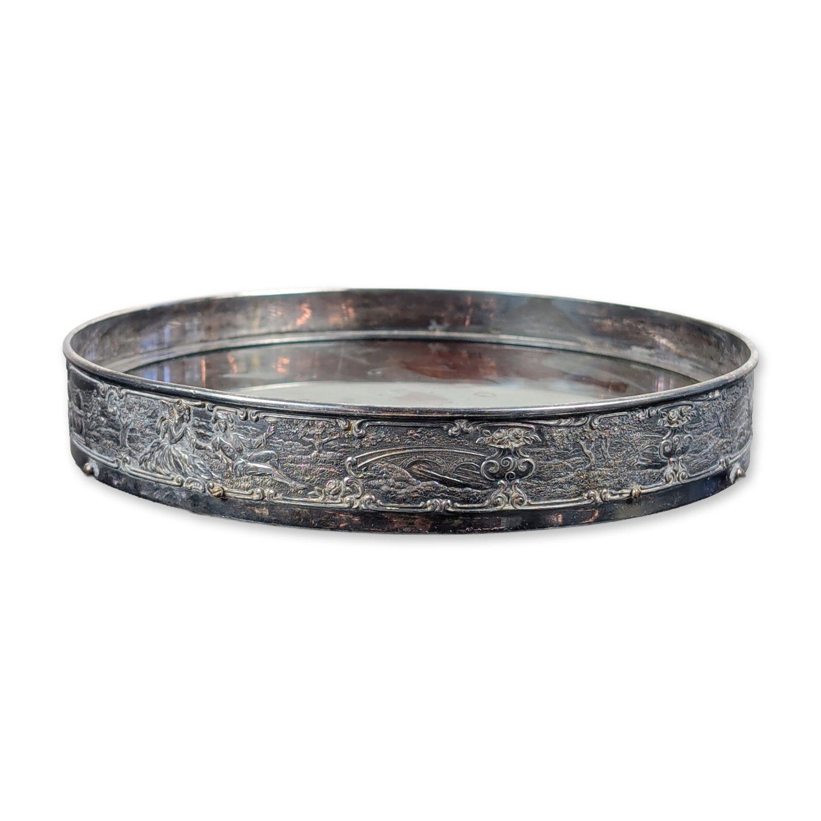Antique Wilcox Silver Plate Co Pastoral Vanity Tray: This late 19th century Rococo Revival style vanity coaster features an ornate metal gallery paired with a dark wood base. The circular gallery is decorated in high-relief repousse detailing peacocks, 