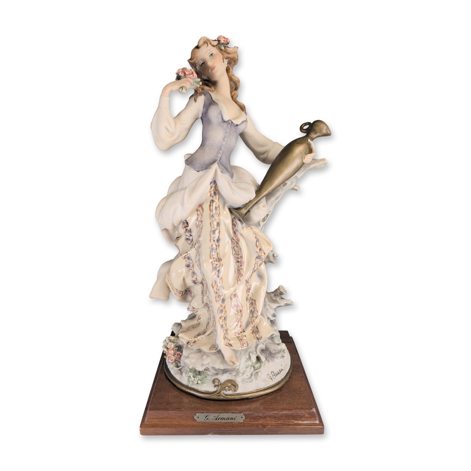 Giuseppe Armani Florence Sculture d'Arte Studio Sculpture, Lady With Amphora: Depicted in a dynamic forward-leaning pose, draped in flowing robes, holding an elongated amphora vase in her right hand and a small bouquet of roses in her left. The woman wears a textured lavender-g