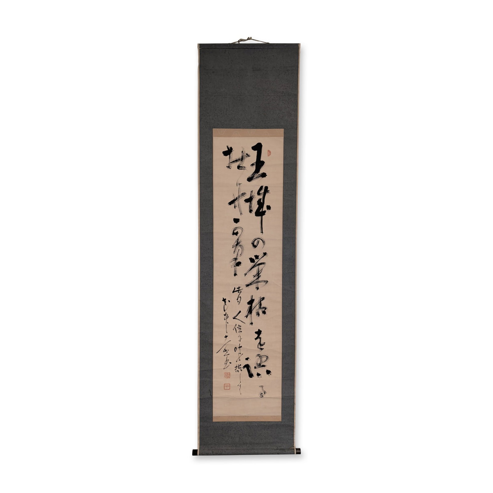 Japanese Ink on Paper Calligraphy Hanging Scroll: Japanese hanging scroll in sumi ink on paper featuring calligraphy in cursive grass script using the dry brush flying white technique. The central panel is mounted with dark grey-green silk borders an
