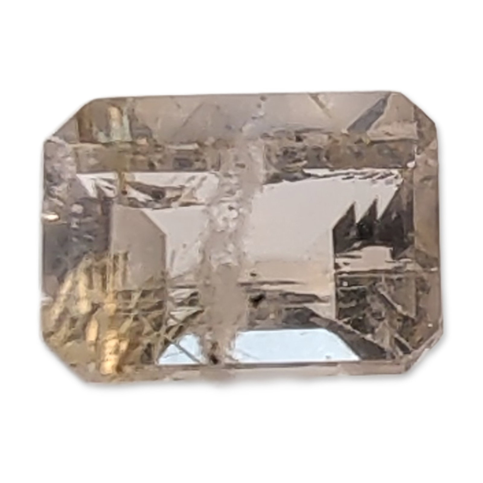Rectangular Step Cut Champagne Quartz Gemstone: Rectangular step cut loose champagne quartz gemstone. The stone exhibits a light yellowish-brown hue with dense internal characteristics, including fine needle-like inclusions and dark salt and pepper