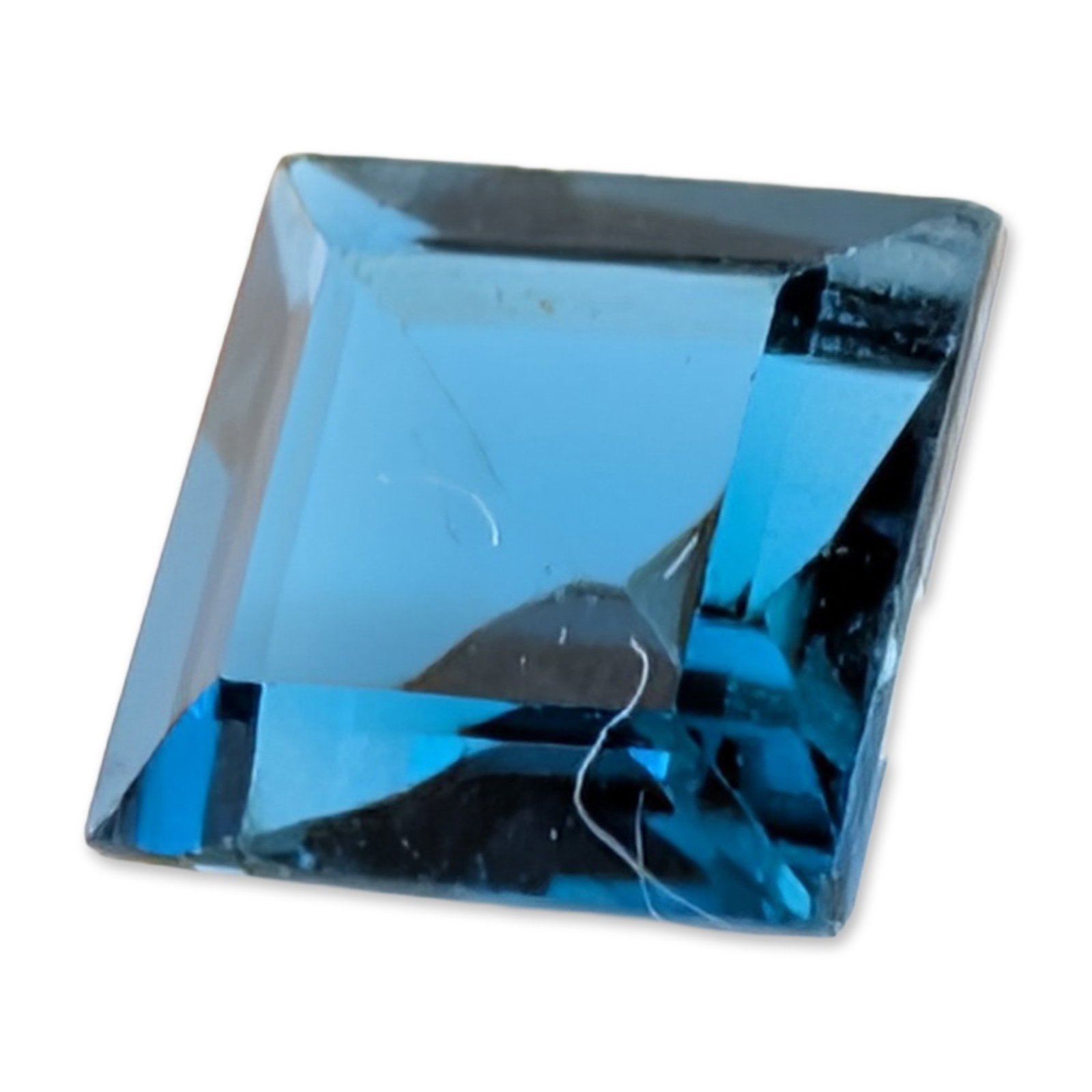 Princess Cut Loose Blue Topaz Gemstone: One loose topaz gemstone, square princess cut, in a saturated navy blue color. The stone displays an internal diagonal feather visible through the table. 1.3 carats 6.1 mm x 6.1 mm. Dimensions: 6.1mm