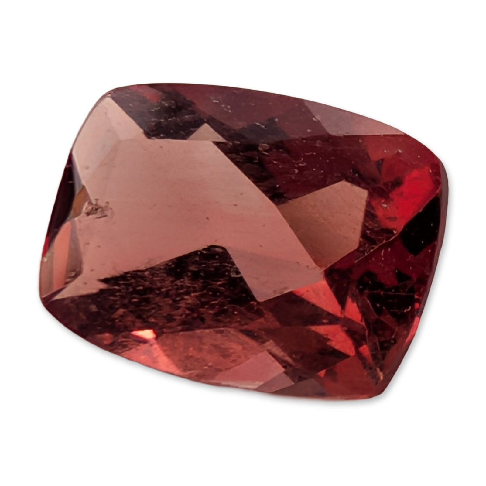 Cushion Cut Pink Stone: Loose faceted stone featuring a cushion-shaped mixed cut with a saturated reddish-pink hue and distinct orangey-brown undertones. Weight: 0.60 ct. Dimensions: 7H MM