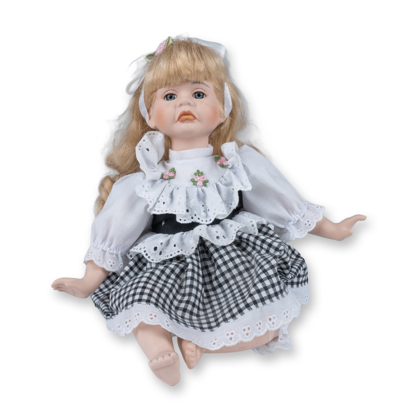 Crying Porcelain Sitting Doll: A collectible highlighting Crying Porcelain Sitting Doll. Cute toy wearing a checkered skirt with lacy edges and a band aide on her knee, causing some tears. Dimensions: 11"L x 8"W x 11"H