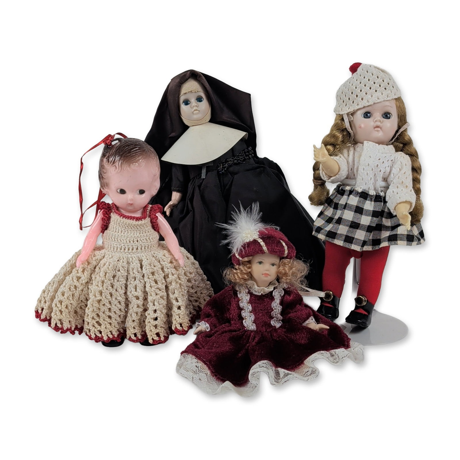 Group of Four Assorted Collector Dolls: Assortment of four collector dolls in varying materials, including porcelain and hard plastic. The group features a doll with plastic head and blonde braids in a winter ensemble with a checkered skirt