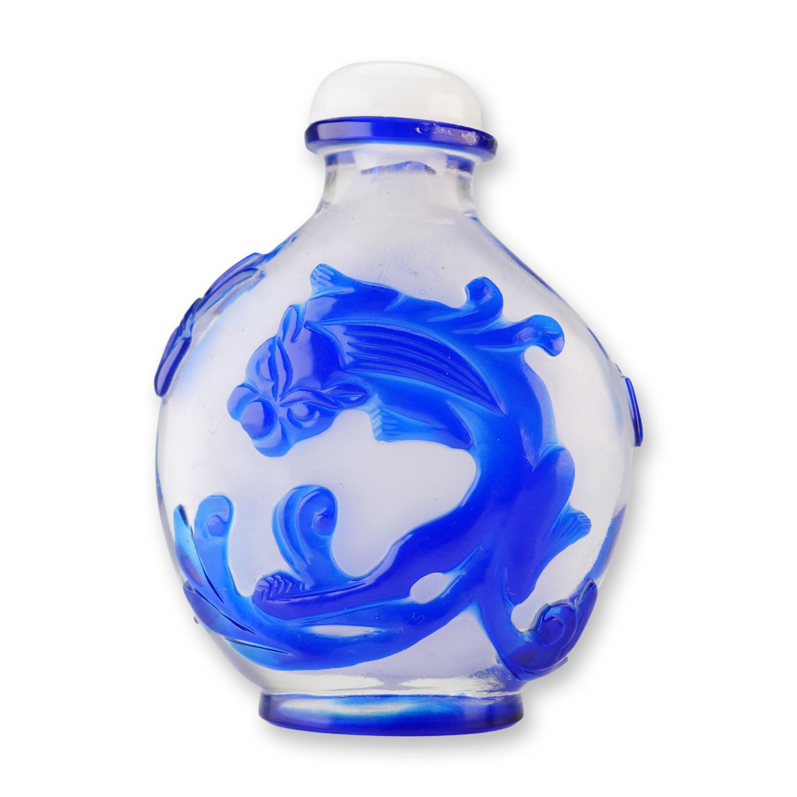 Peking Glass Snuff Bottle, Blue Overlay Chilongs: A round Peking glass snuff bottle featuring a soft white hue, adorned with a blue relief overlay portraying chilongs. It is topped with a white stopper. Dimensions: 2.25"L x 1"W x 3"H Weight: 2.8 oz