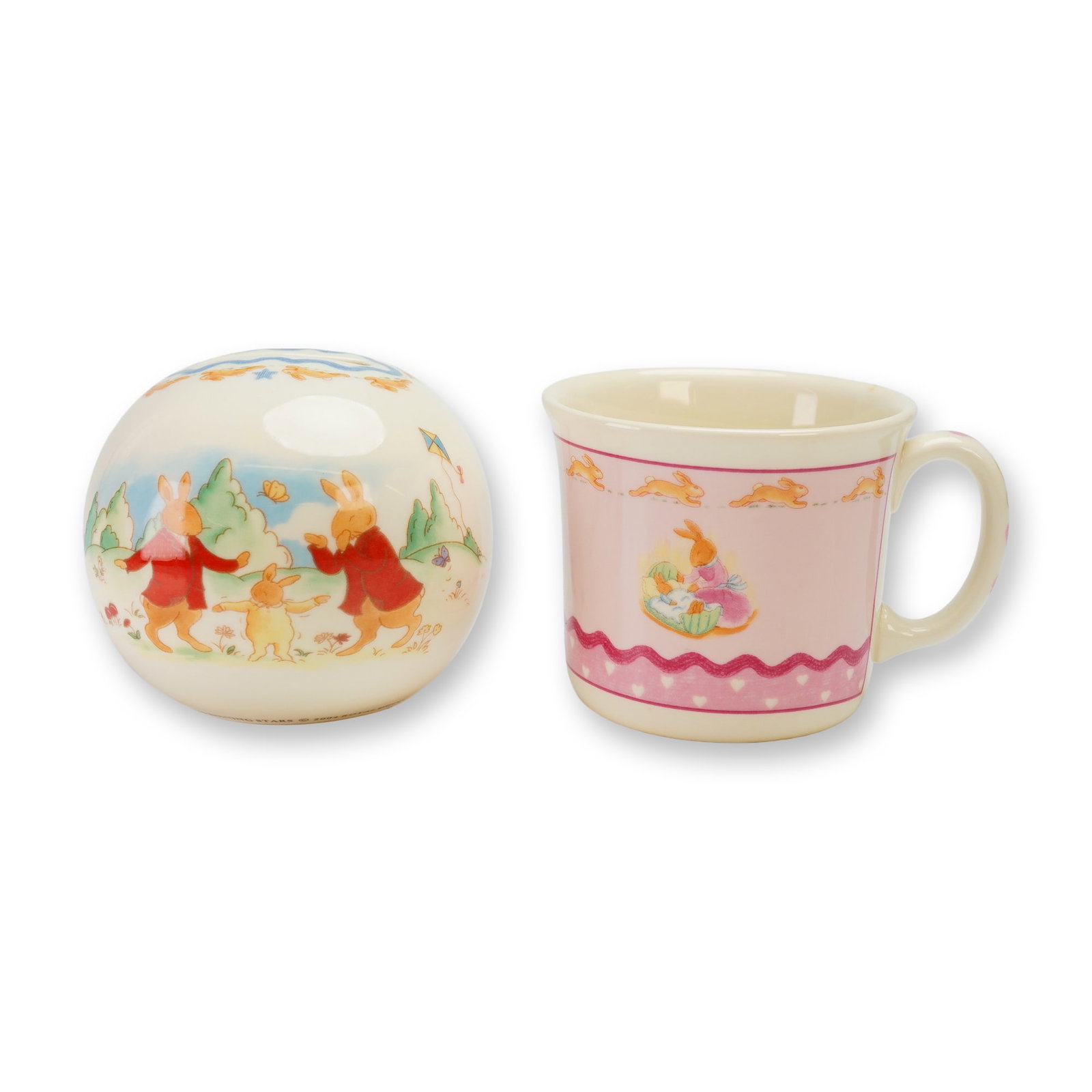 2pc Royal Doulton Bunnykins Bone China Money Ball and Mug: This 2pc Royal Doulton Bunnykins bone china set consists of a money ball and a mug. The money ball is from the Shining Stars series and is constructed as a spherical bank featuring a coin slot at the 