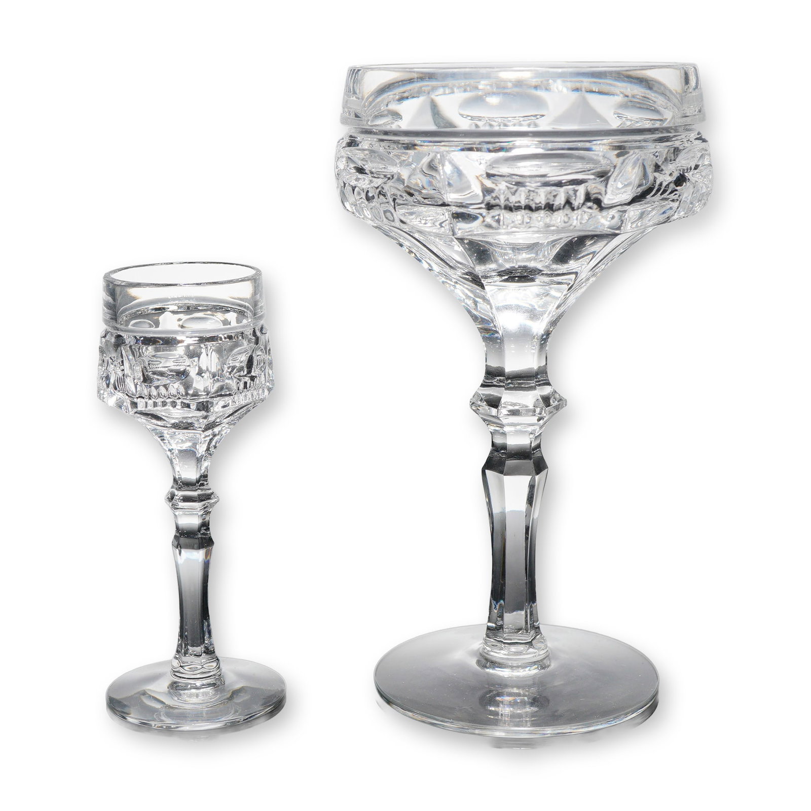 2pc Clear Cut Crystal Champagne and Cordial Glasses: Two clear cut crystal stem glasses, including one champagne coupe and one cordial glass. Each features faceted detailing and hexagonal stems with polished bases. Dimensions: Largest item (champagne gl