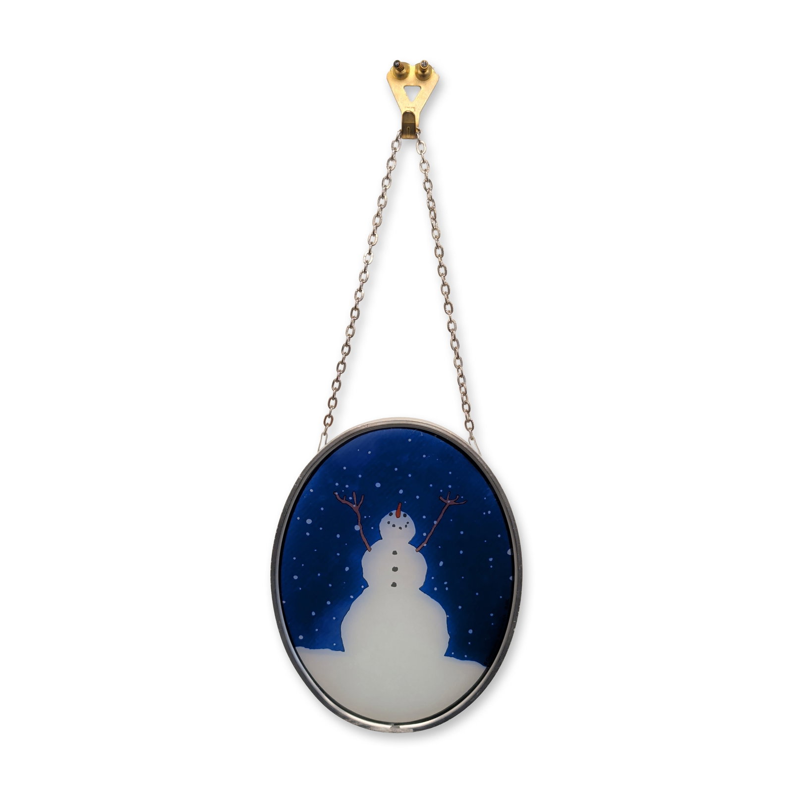 Glassmasters Enameled Glass Sher Schier Snowman Suncatcher: Glassmasters enameled glass suncatcher in an oval metal frame, depicting a snowman with twig arms and an orange carrot nose against a dark blue starry night sky. Illustrated by Sher Schier for The Art