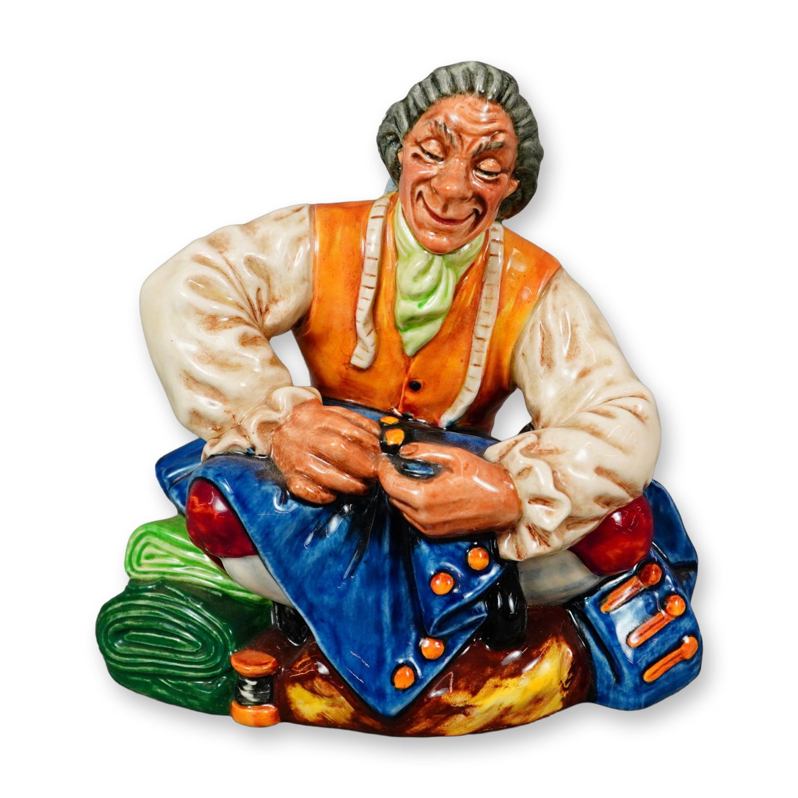 Royal Doulton Porcelain Figurine, Tailor HN2174: Part of the Character Study - Nicoll series. Designed by Mary Nicoll. Hand painted figure of a seated man sewing yellow buttons on a blue jacket. Royal Doulton backstamp. Artist: Mary Nicoll Dimension