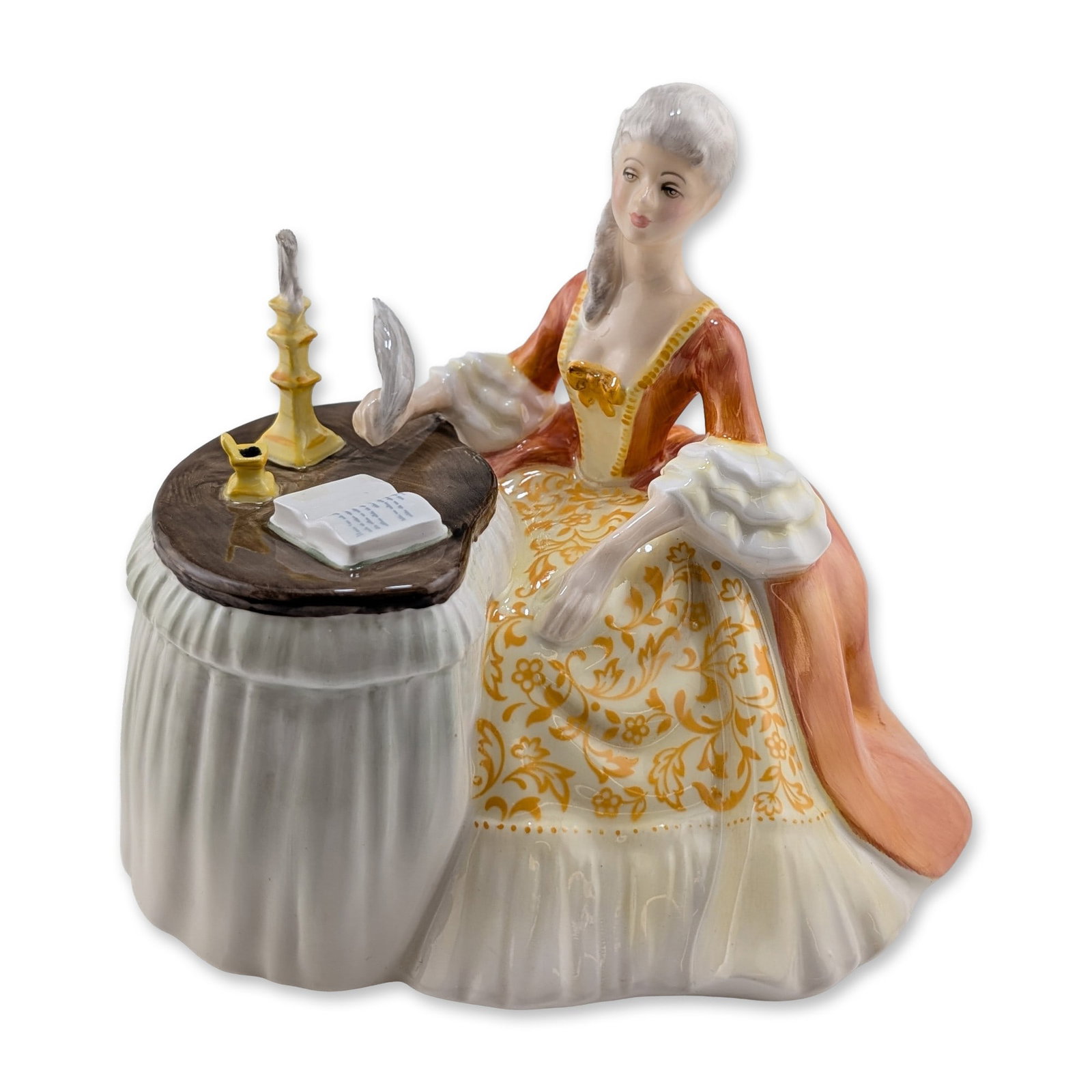 Royal Doulton Bone China Figurine, Meditation HN2330: Glazed porcelain figurine depicting a woman in 18th-century attire seated at a table. The figure is shown writing in an open book with a quill pen, alongside a yellow candlestick and inkwell on the br