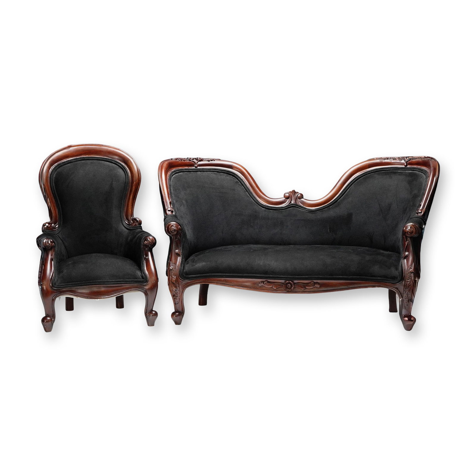 2pc Indonesian Mahogany Child's Puppensofa & Chair: A finely crafted two-piece set of mahogany furniture, featuring a richly carved wooden frame and black upholstered surfaces. The set includes an elegant sofa with a gracefully curved backrest adorned 