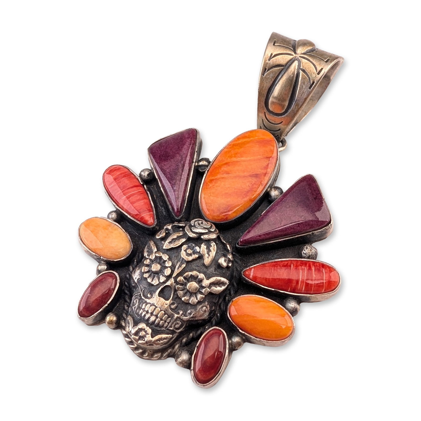 Robert Livingston Navajo Sterling Silver Spiny Oyster Skull Pendant: Navajo sterling silver and multi-stone cluster pendant featuring a central three-dimensional sugar skull with floral engravings and oxidized recesses. The skull is surrounded by nine spiny oyster shel