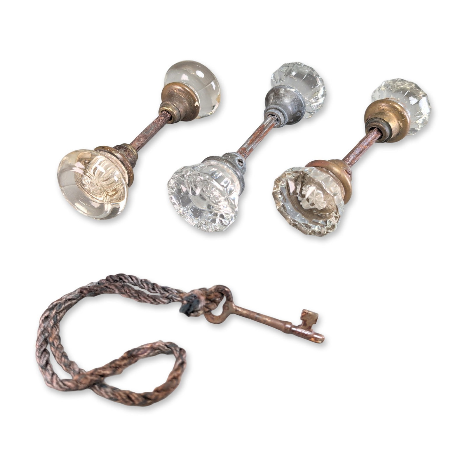 4pc Collection of Antique Glass Doorknobs and Key: Collection of early 20th century door hardware featuring three pairs of glass doorknobs and a single skeleton key. The assortment includes clear glass knobs in 12-point fluted star and rounded multi-f