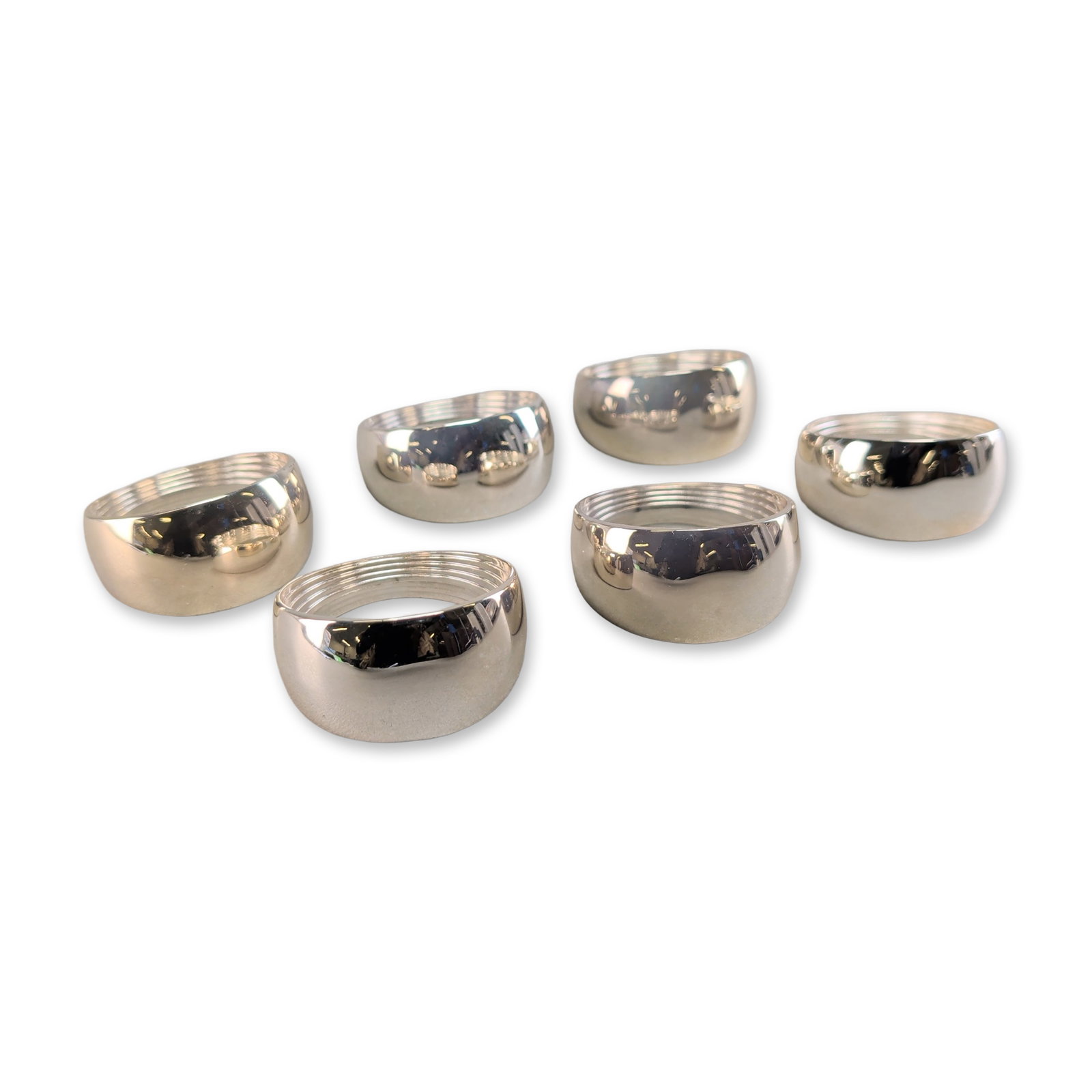 Newbridge Silverware Silver Plated Napkin Rings Group: A set of six napkin rings by Newbridge Silverware, featuring a circular form with a convex exterior profile and decorative concentric ribbing to the interior surfaces. Each ring is finished in a high-