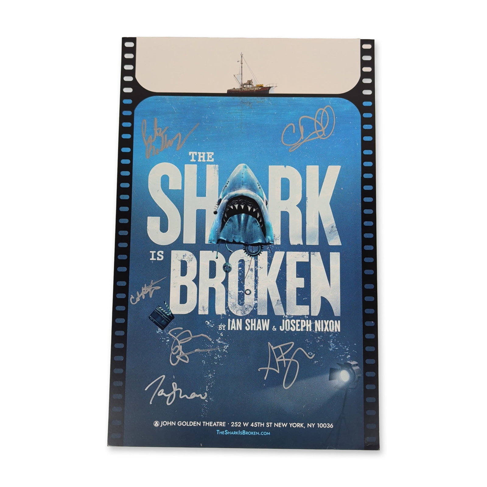 The Shark is Broken Signed Broadway Window Card: Broadway window card for the production of The Shark is Broken at the John Golden Theatre. The printed cardstock poster features stylized shark imagery breaking through the title, a film strip border,