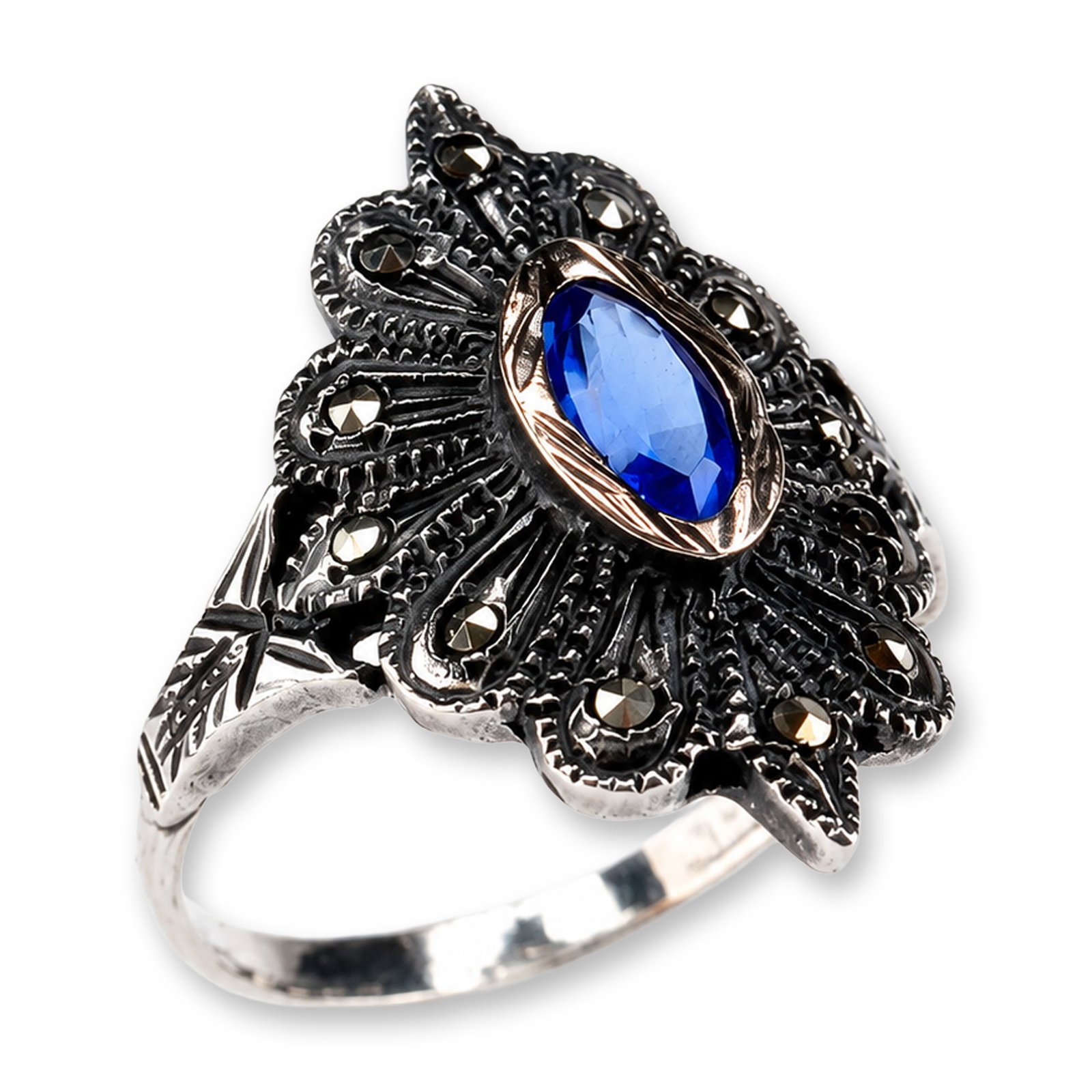 European Silver Blue Stone and Marcasite Ring: Vintage-revival style cocktail ring in silver with an oxidized finish. The design features a marquise-cut medium blue stone secured in a gold bezel setting. The decorative head is composed of a radiat