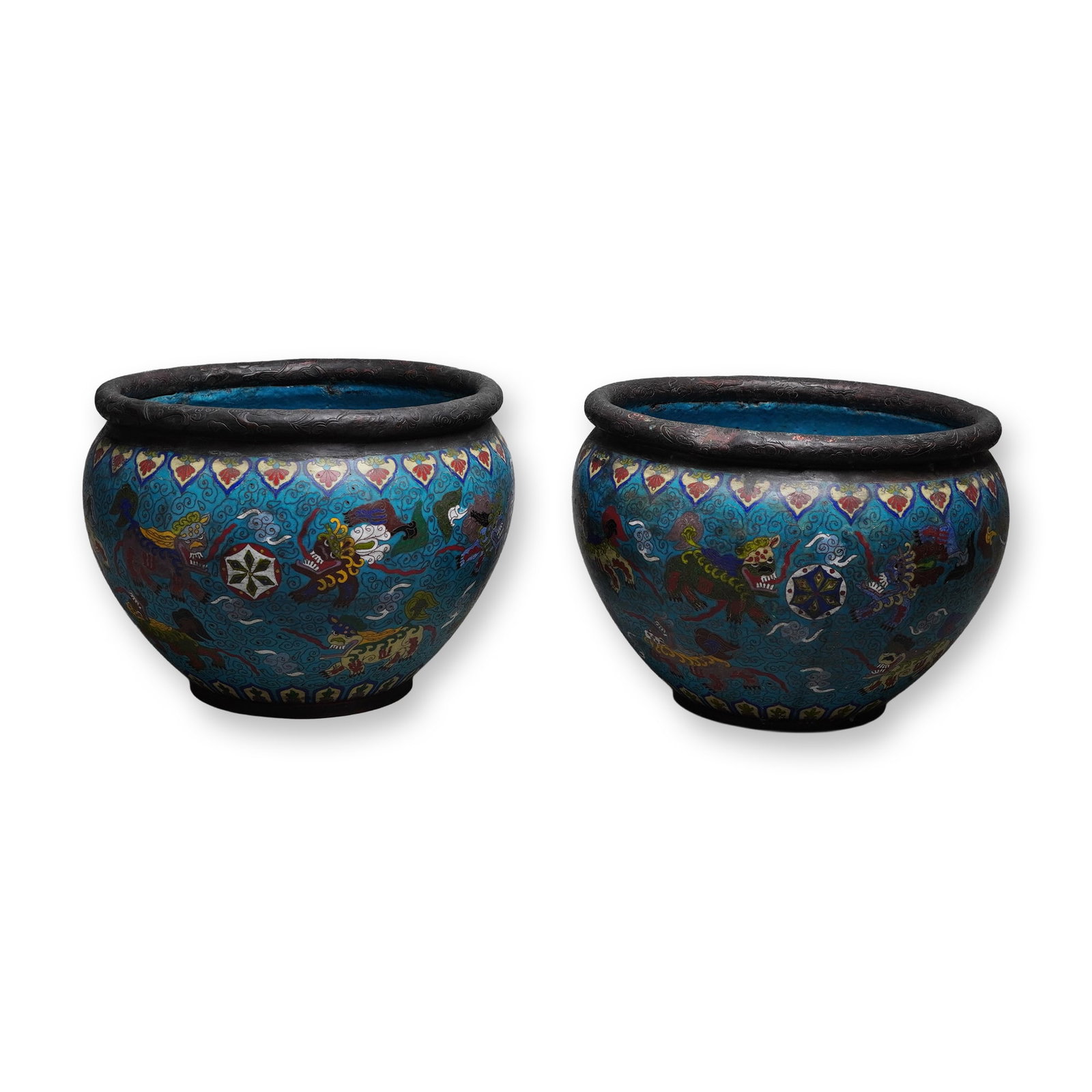2pc Chinese Cloisonne Planters Buddhist Foo Dog Design: This selection of cloisonne planters features matching turquoise-colored ground vessels decorated with multiple polychrome Buddhist guardian lions amidst cloud scrolls and brocade balls. The rounded v