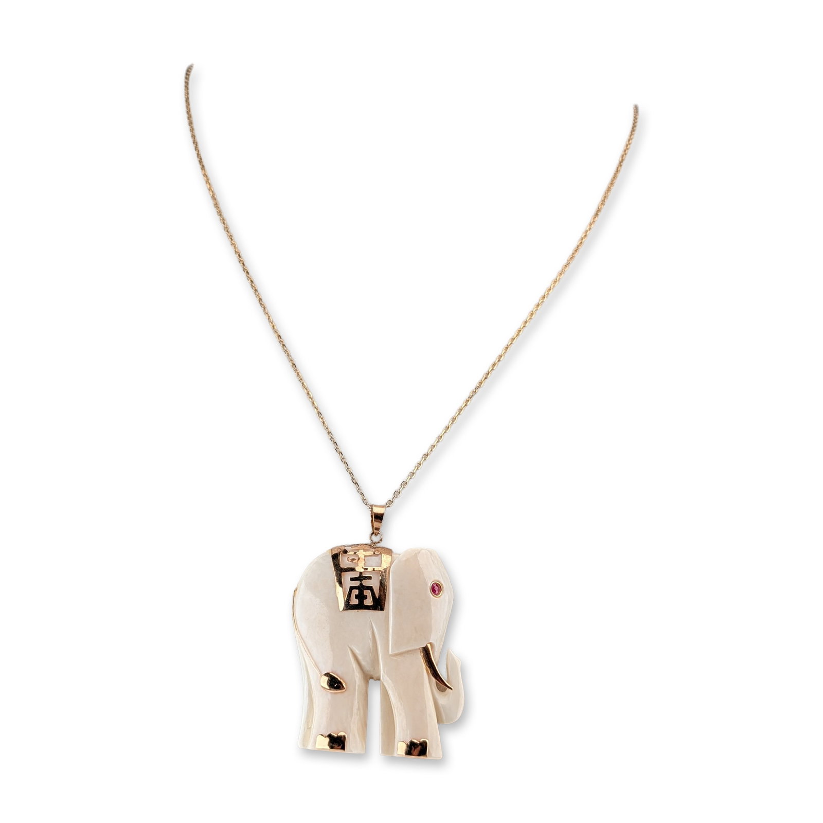 14K Yellow Gold Carved Elephant Pendant on a Sterling Silver Chain Necklace: A carved cream-colored organic material pendant depicting an elephant with its trunk raised. The pendant is embellished with 14k yellow gold accents including the tusks, tail, and feet. A decorative g