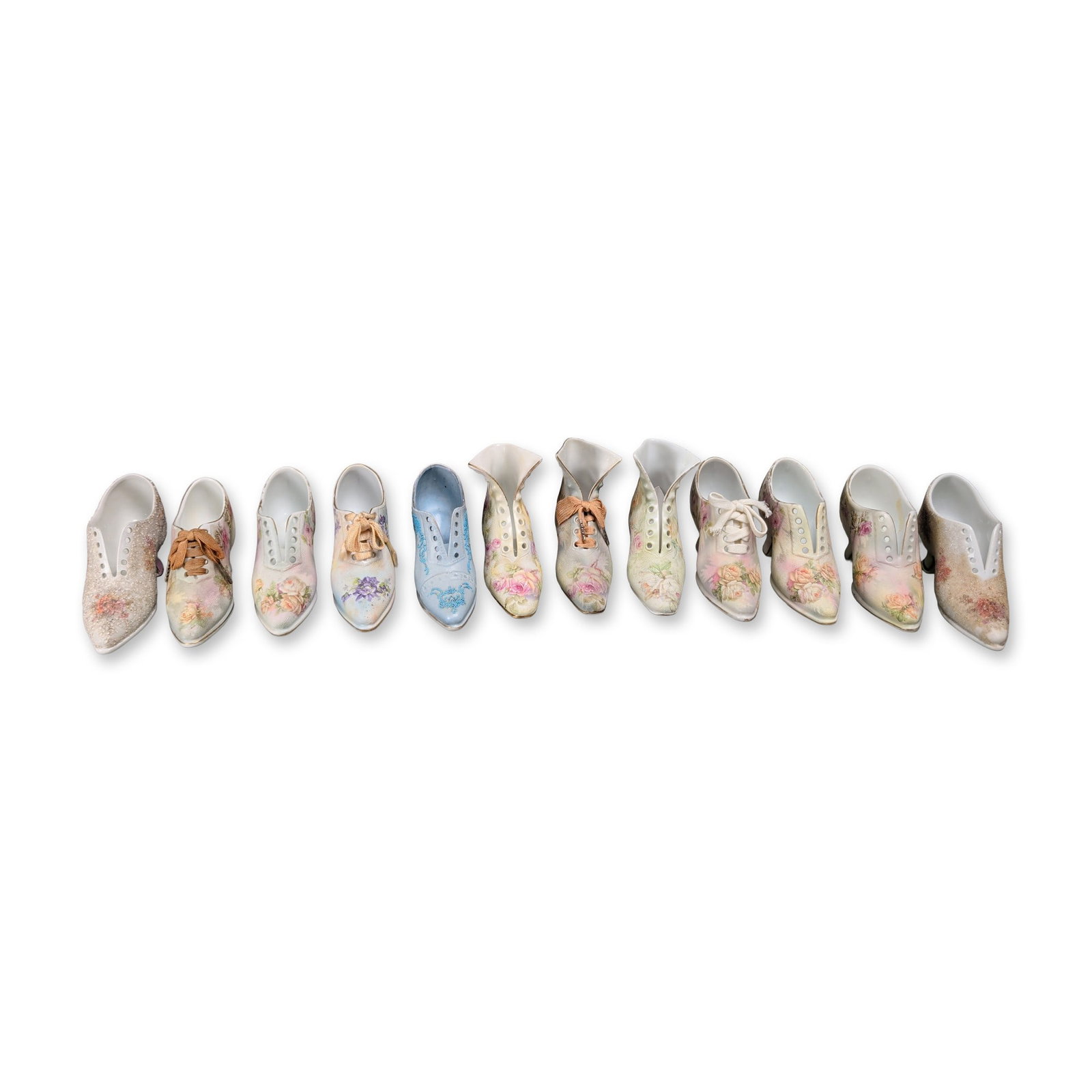 12pc Royal Bayreuth Bavaria and Assorted Porcelain Floral Shoe Figurine Collection: A collection of twelve porcelain shoe figurines in various Edwardian and Victorian styles, including high-button boots, lace-up oxfords, and pointed-toe pumps. The pieces feature glazed and bisque fin