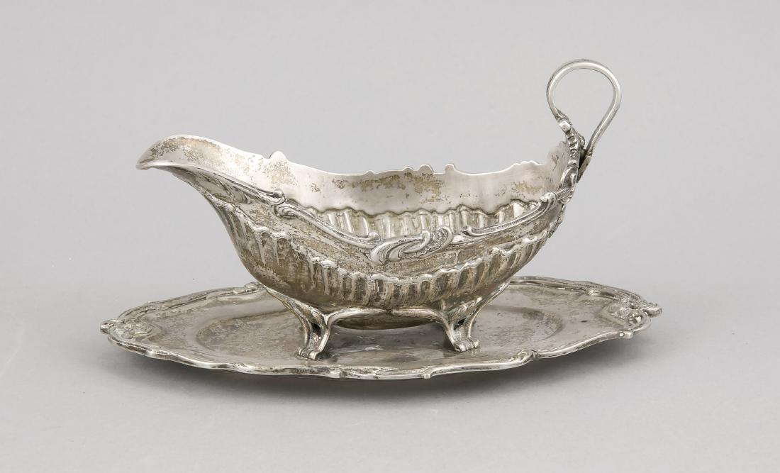 Sauce boat, 20th cent., silver 800/000, curved saucer,: Sauce boat, 20th cent., silver 800/000, curved saucer, sauce boat on 4 feet, curved form,sidely attached handle, wall with relief decoration, l. 23 cm, approx. 426 g German: Saucière, 20. Jh., Silbe