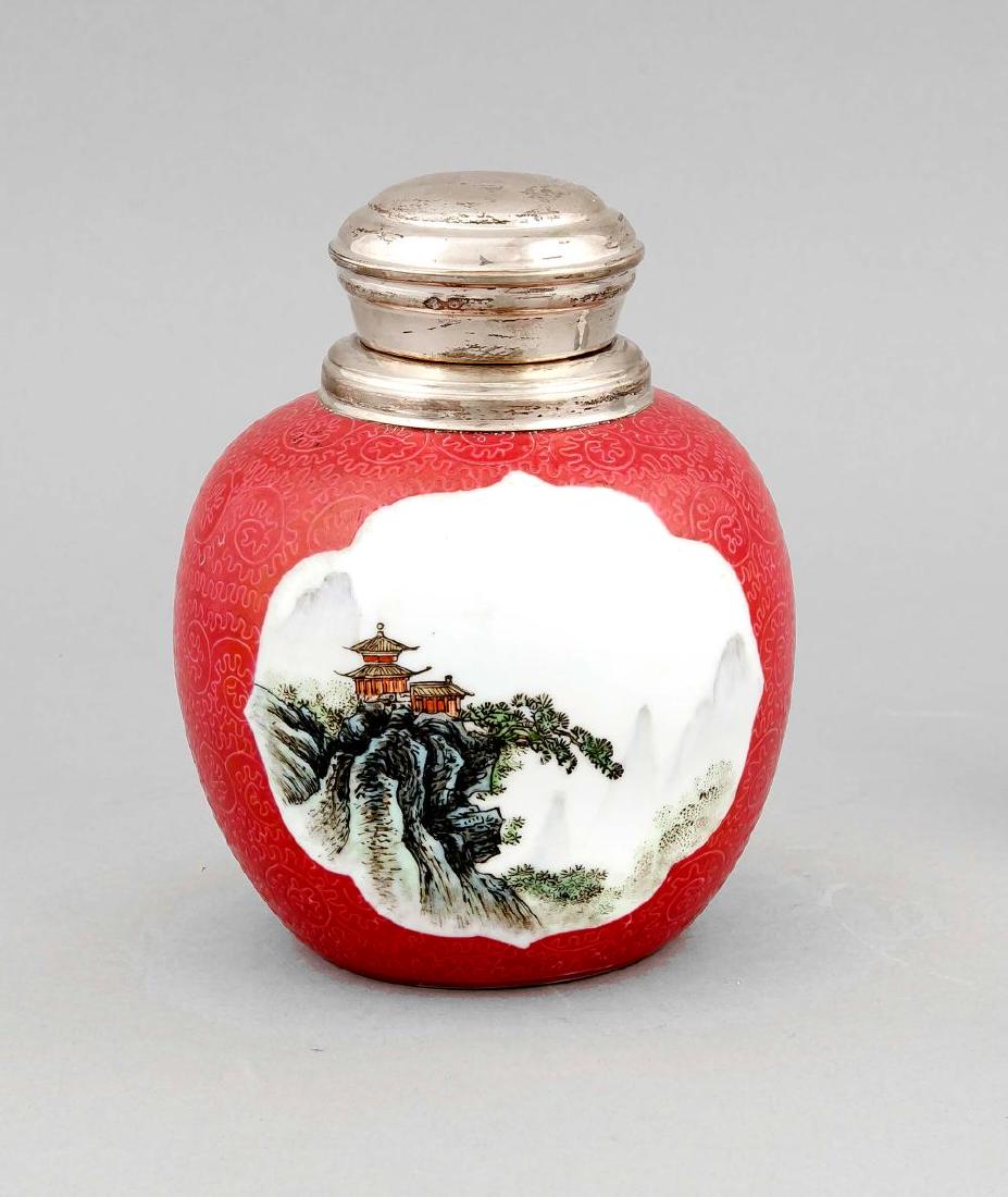 A Chinese Mid-20th century ginger jar, the porcelain: A Chinese Mid-20th century ginger jar, the porcelain body with two reserves depicting landscapes in greenish blue, incised decor on light red ground, the lid silver mounted (Dutch, 833/000 silver), h.