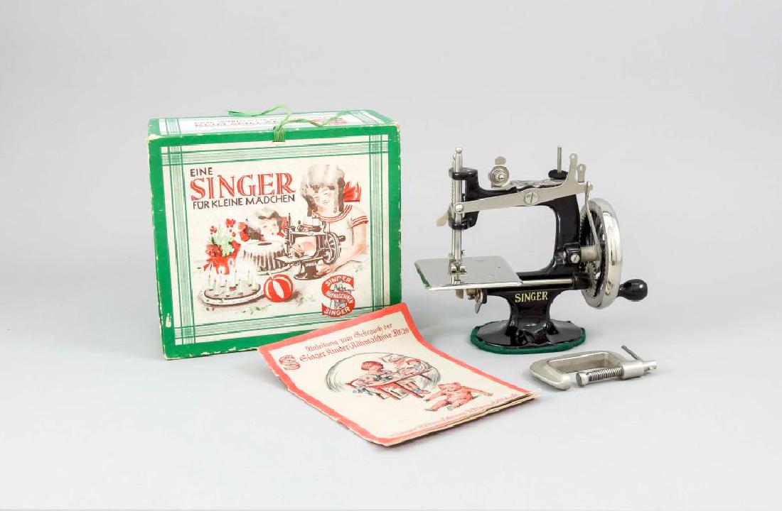 Child sewing ma: Child sewing machine by Singer, Germany, 1920s. In the original box, with screw mechanism for attaching to a table, user manual, very good condition, dimensions cardboard approx. 10 x 18 x 20 cm