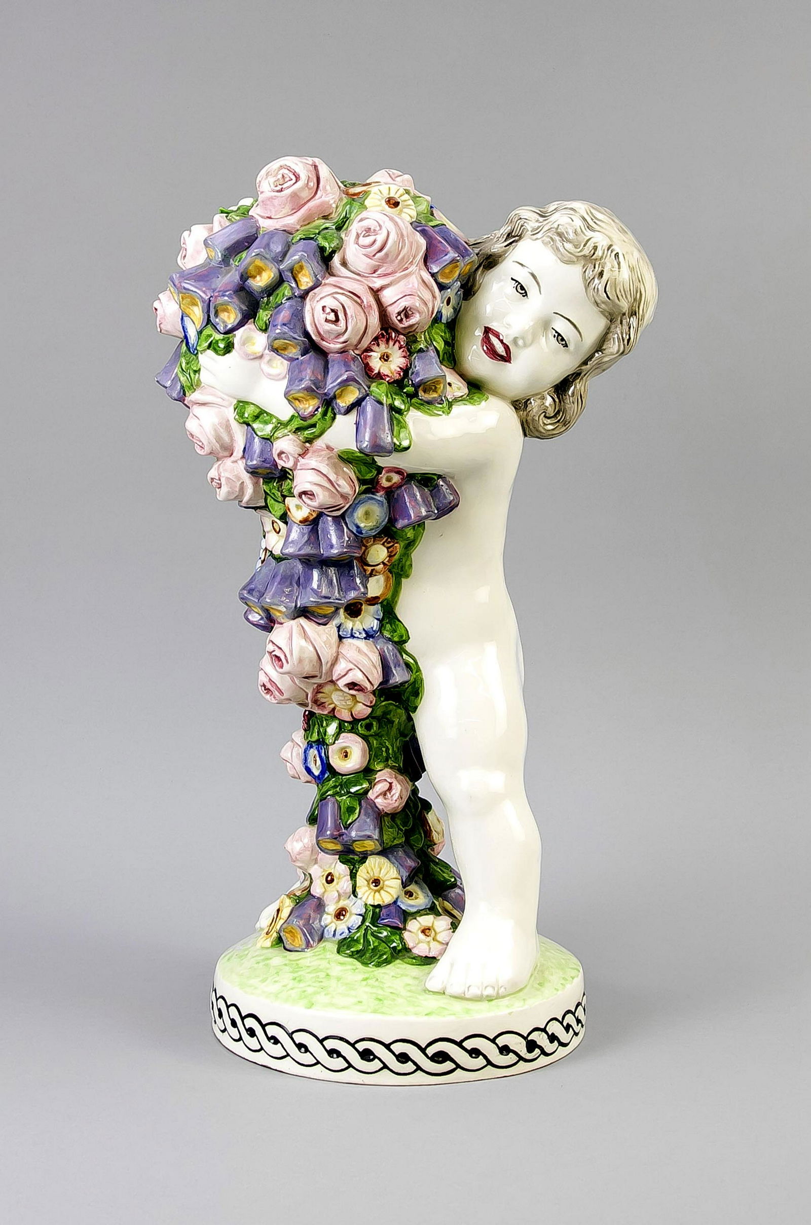 Putto with flower garland, probably Bernard Bloch,: Putto with flower garland, probably Bernard Bloch, Eichwald, c. 1910-20, designed by Carl Klimt (1876-1945), model no. 9389, ceramic, bright body, polychrome painted, putto, carrying a huge flower gar
