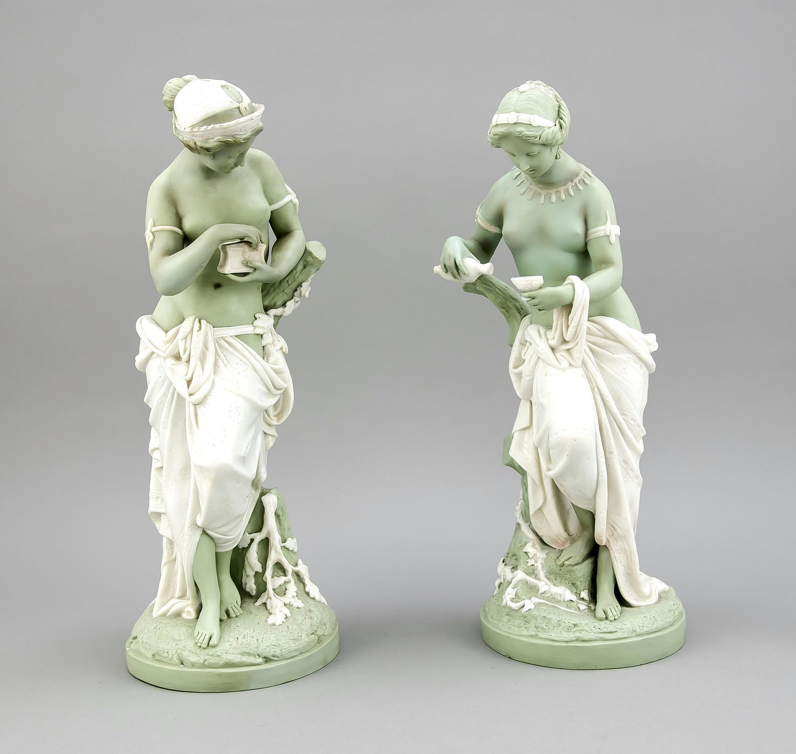 Pair of Victorian pendant figurines, Minton, England,: Pair of Victorian pendant figurines, Minton, England, late 19th c., parian ware, partly tinted in celadon a. with white glaze, classical female figures leaning against a tree trunk, on round naturalis