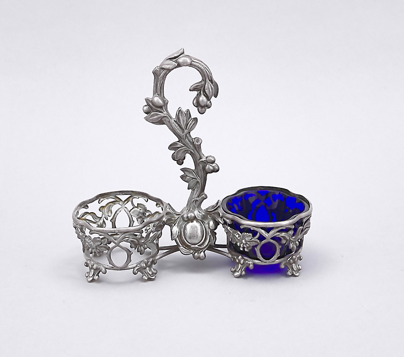 Cruet stand, France, 1911: Cruet stand, France, 1911-16, hallmarked Alphonse Debain, Paris, on 8 feet, openworked wall with rich floral decoration, curved middle handle, cobalt blue glass insert (one missing), L. 16.5 cm, weigh