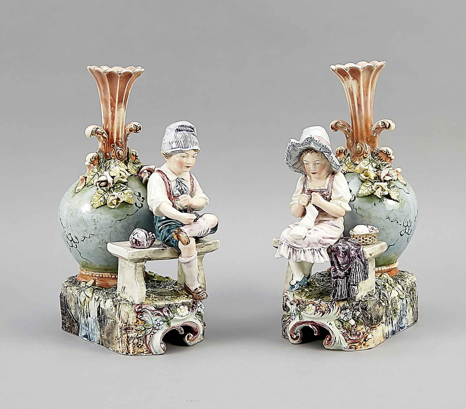 Pair of figural vases, En: Pair of figural vases, England, 20th century, vases with sculptural flowers on naturalist. designed base, a boy with pipe and a knitting girl sitting on benches, polychrome painted, min. chip., H. 30 