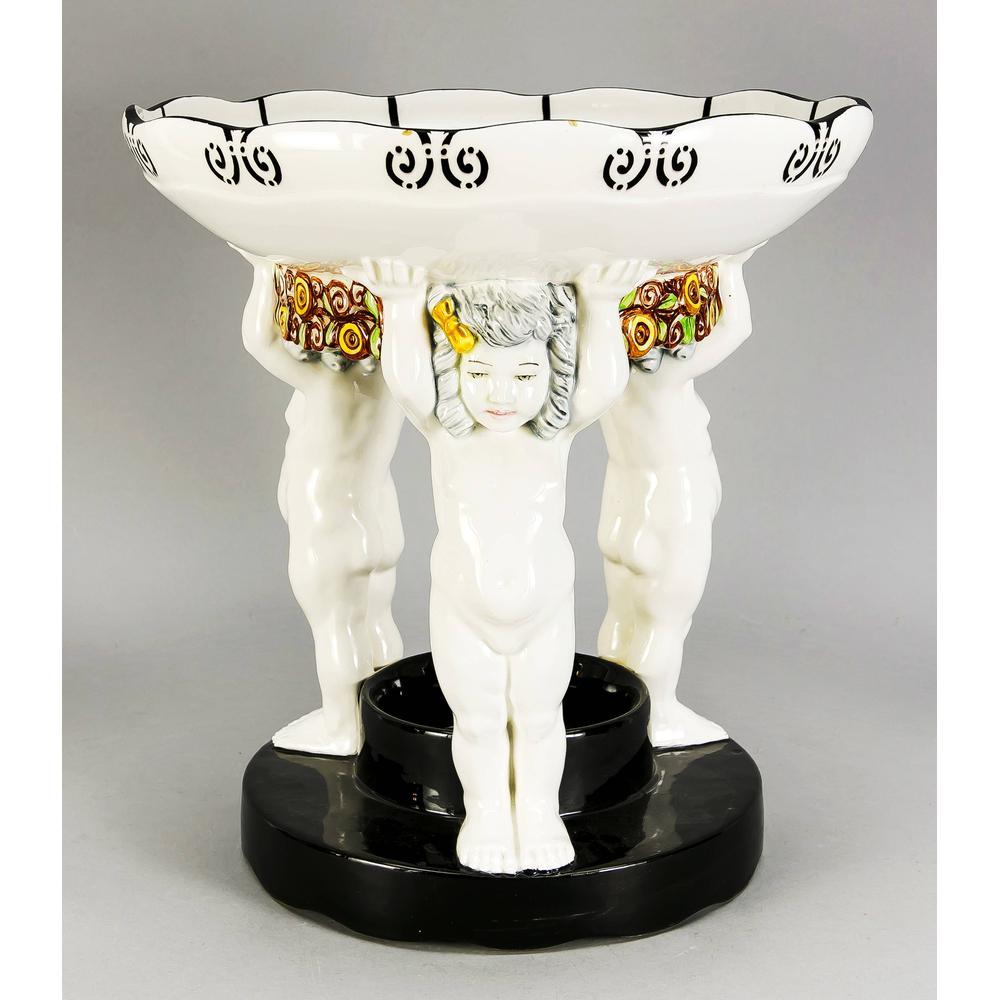 Large Art Nouveau bowl, B: Large Art Nouveau bowl, Bohemia, around 1900, probably Carl Klimt (1867-1945), three putti with raised hands carrying a round bowl, connected by flower garlands, polychrome painted, on a round foot in