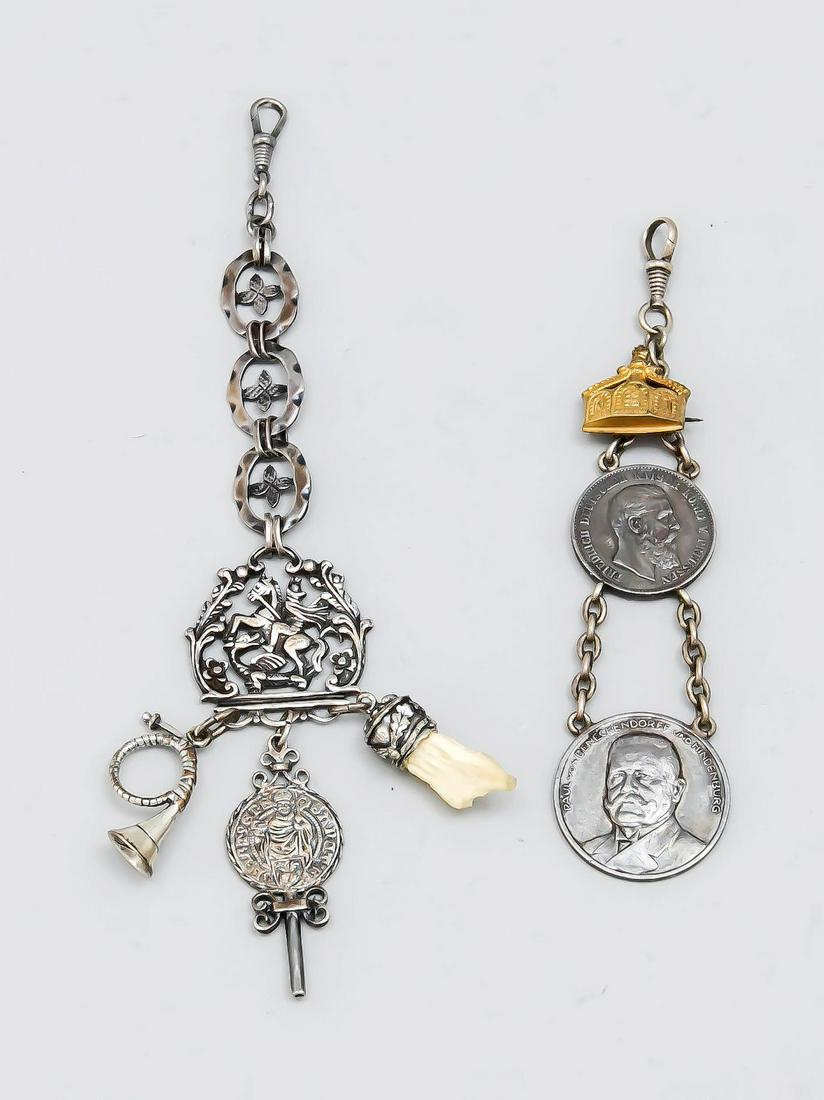 Two chatelaines, around 1: Two chatelaines, around 1900, silver tested, 1 with 2 coins, 1 openworked with different pendants, l. up to 19 cm, total gross weight approx. 74 g
