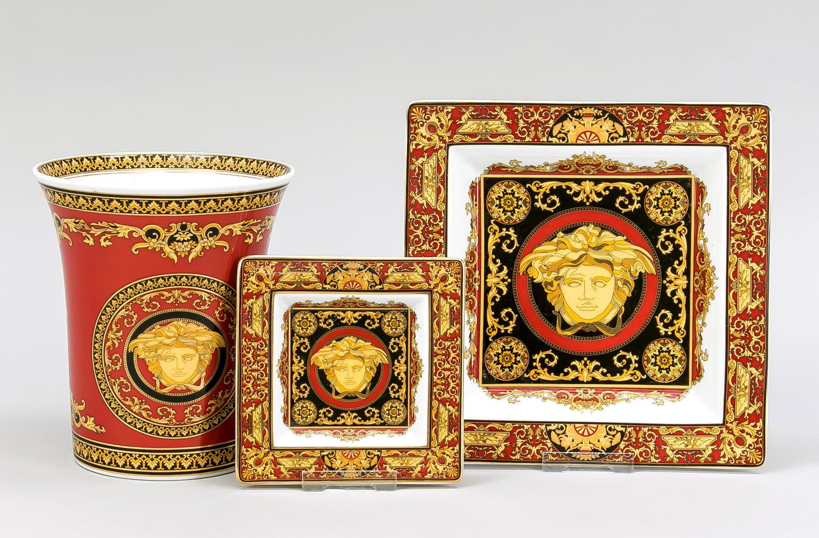 Three ornamental pieces, Rosenthal,: Three ornamental pieces, Rosenthal, late 20th c., Versace design for Rosenthal, Medusa decor, rich ornamental gilding, vase, h. 17,5 cm, 2 square bowls, 13 x 13 cm, and 22 x 22 cm.