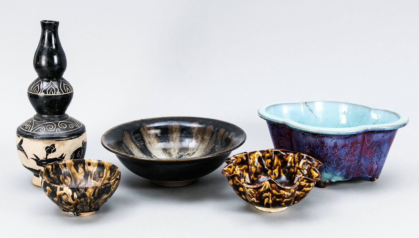 5 pieces of pottery, China, 20th c.: 5 pieces of pottery, China, 20th c. 1 x fitted curved bowl (cachepot) with Jun glaze, glued. 2 x small bowls (1 of them with lobed wall) with turtle shell glaze. 1 bowl with black glaze and a Cizhou s