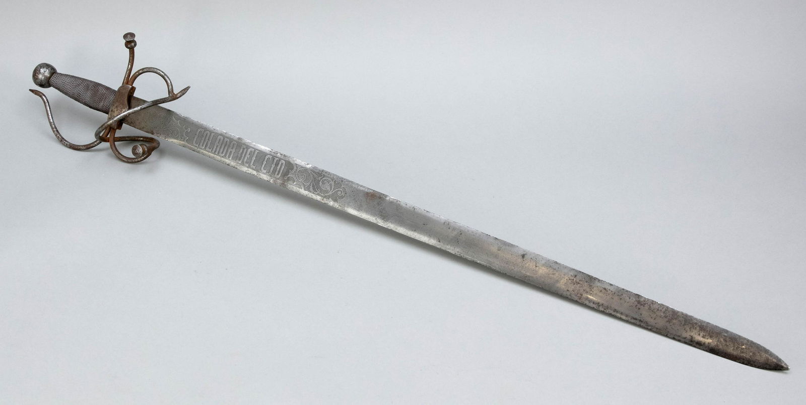 Sword, Spain (probably Toledo): Sword, Spain (probably Toledo), early 20th century, iron. Straight, double-edged (blunt) blade with decoration and inscription ''Colada del Cid''. Handle with iron wire winding and curved quillons, l.