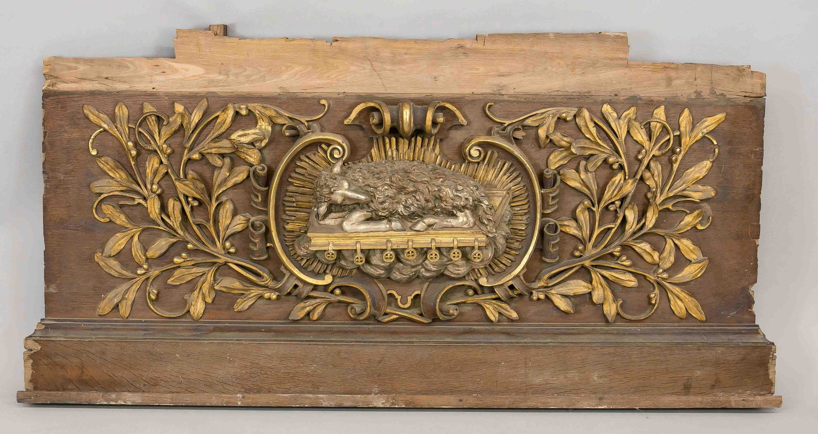Large attachment with a lamb i: Large attachment with a lamb in a corona, end of the 19th century, partially decorated with gold and silver. Rocaillic cartouche surrounded by tendril, bumped especially at the edges, 80 x 157 cm.