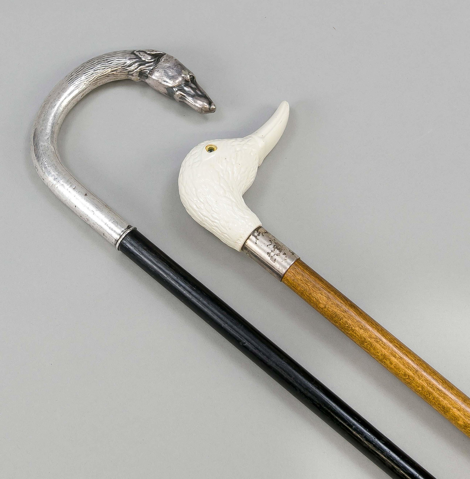 2 walking sticks, early 20th c: 2 walking sticks, early 20th c., 1 x with duck head knob (cast), 1 x with silver-plated dog handle, l. 92 and 98 cm