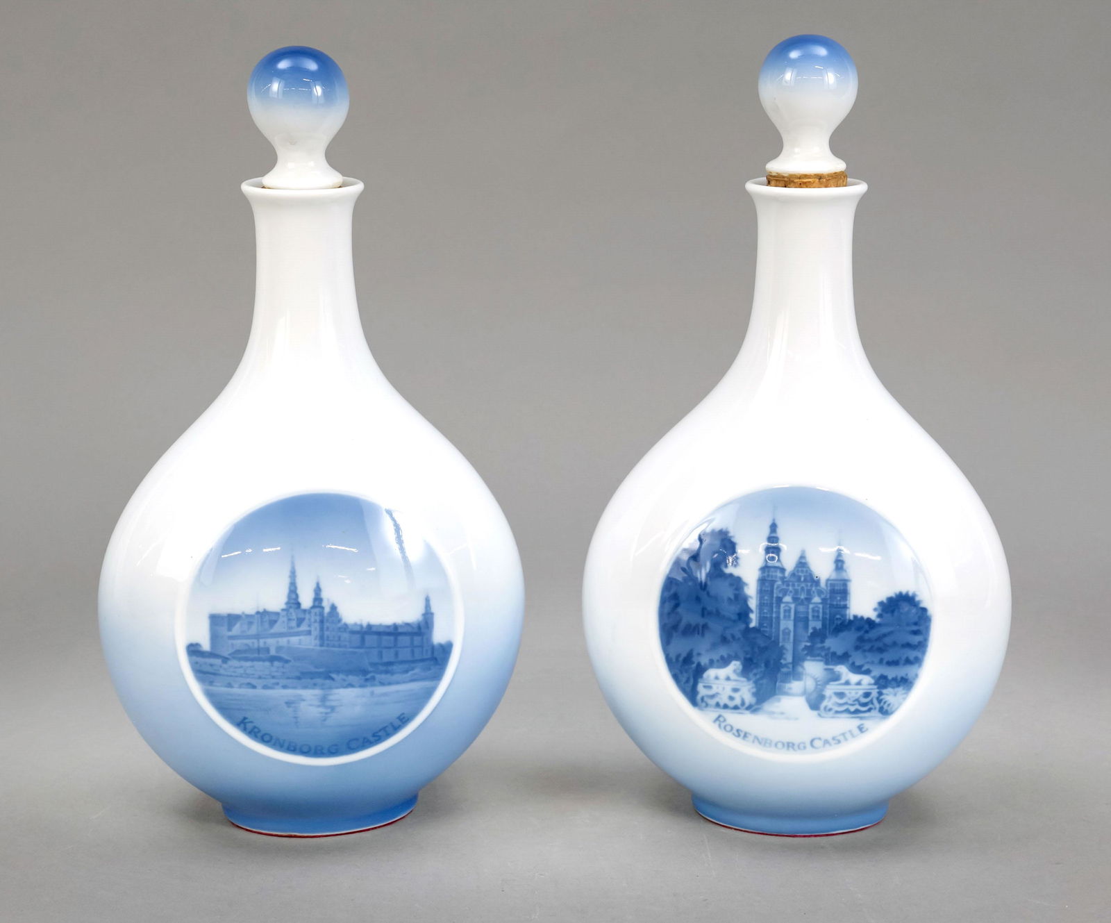Pair of flasks with stoppers,: Pair of flasks with stoppers, Royal Copenhagen, 20th c., pair of tall carafes, bulging downwards, front side with winter views of Rosenborg Castle and Kronborg in underglazed blue, h. 25 cm.