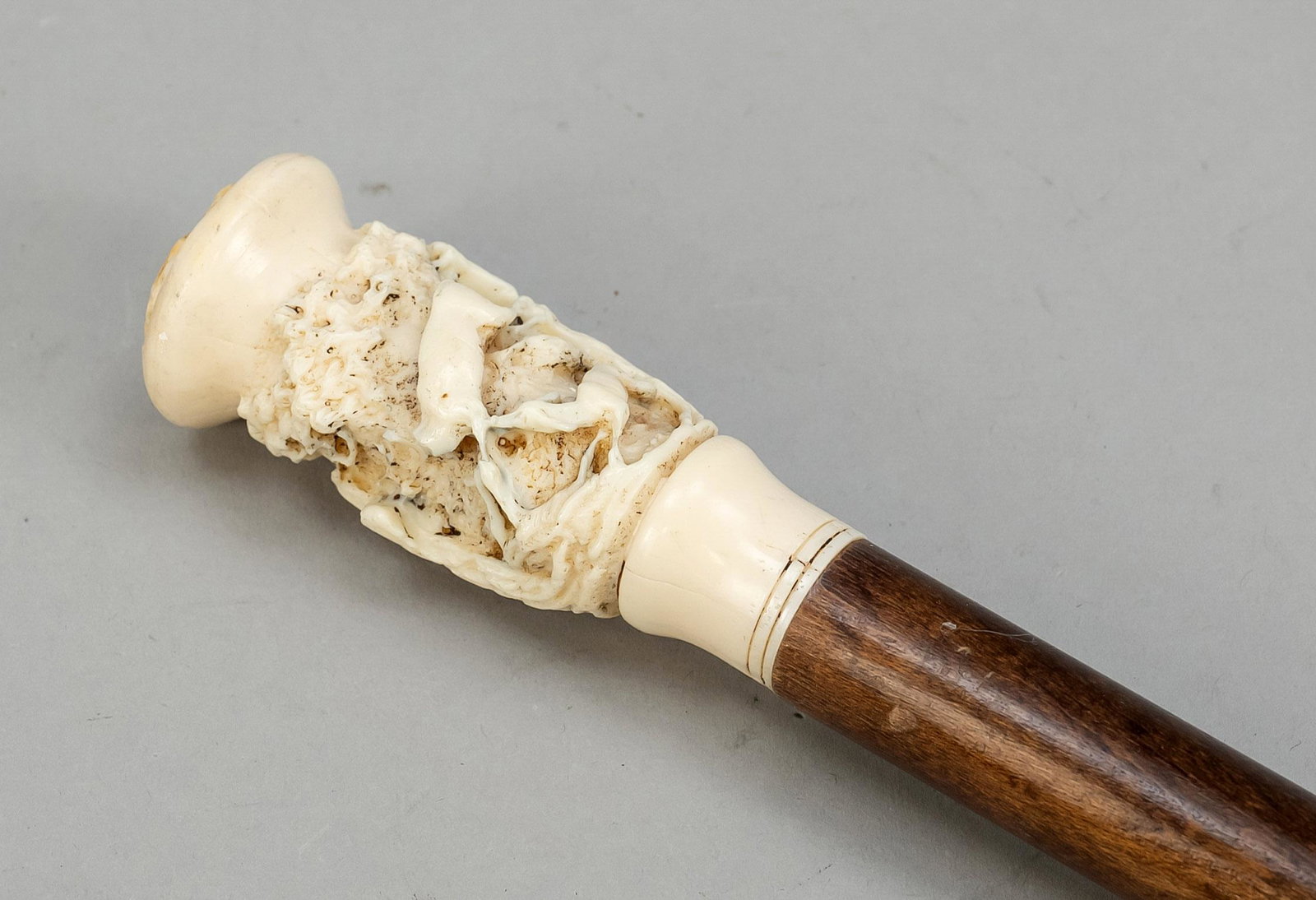 Walking stick with carved pomm: Walking stick with carved pommel, late 19th century. Leg pommel with surrounding hunting carving. Mahogany shaft, brass tip. Knob bumped, l. 93 cm