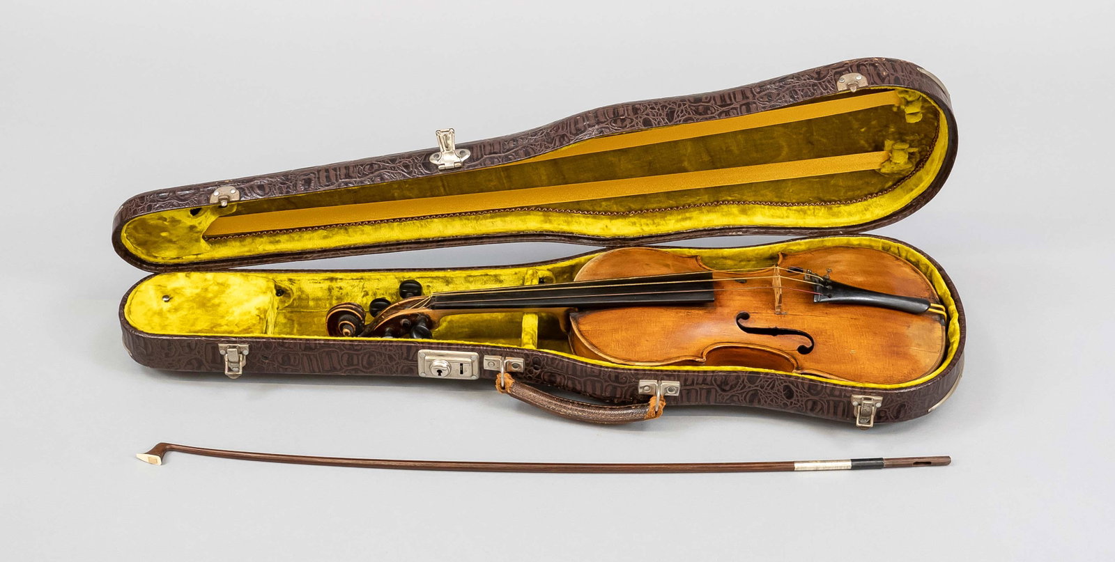 Violin with case, age unknown: Violin with case, age unknown (probably 19th century), without label. Brown case in crocodile leather look lined with greenish velvet. In the lid the stick of a violin bow (unstrung). Violin with mino