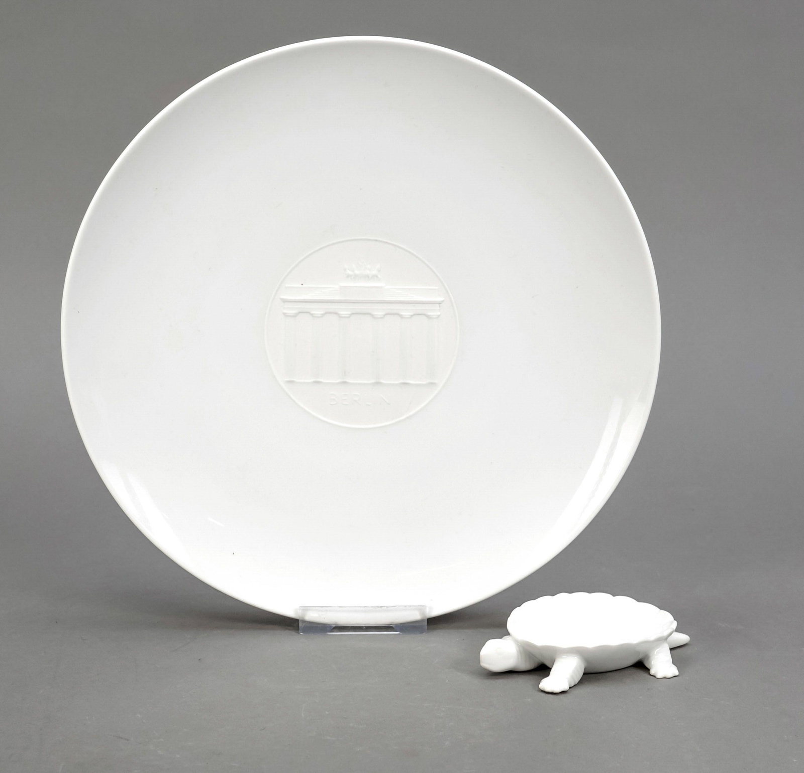 Plate and turtle, KPM Berlin, 2nd hal: Plate and turtle, KPM Berlin, 2nd half, 20th century, white, flat plate with the Brandenburg Gate in white bisque, 1st choice, Ã˜ 25 cm, small bowl in the shape of a turtle, 2nd choice, l. 10 cm.