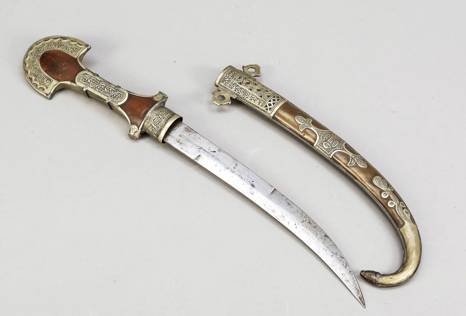 Arabian scimitar, 19th/20th centur: Arabian scimitar, 19th/20th century, double-edged curved blade, wooden handle with ornamented mountings of underalloyed silver? scabbard of brass/copper with ornamented overlays/applications, l. 44 cm