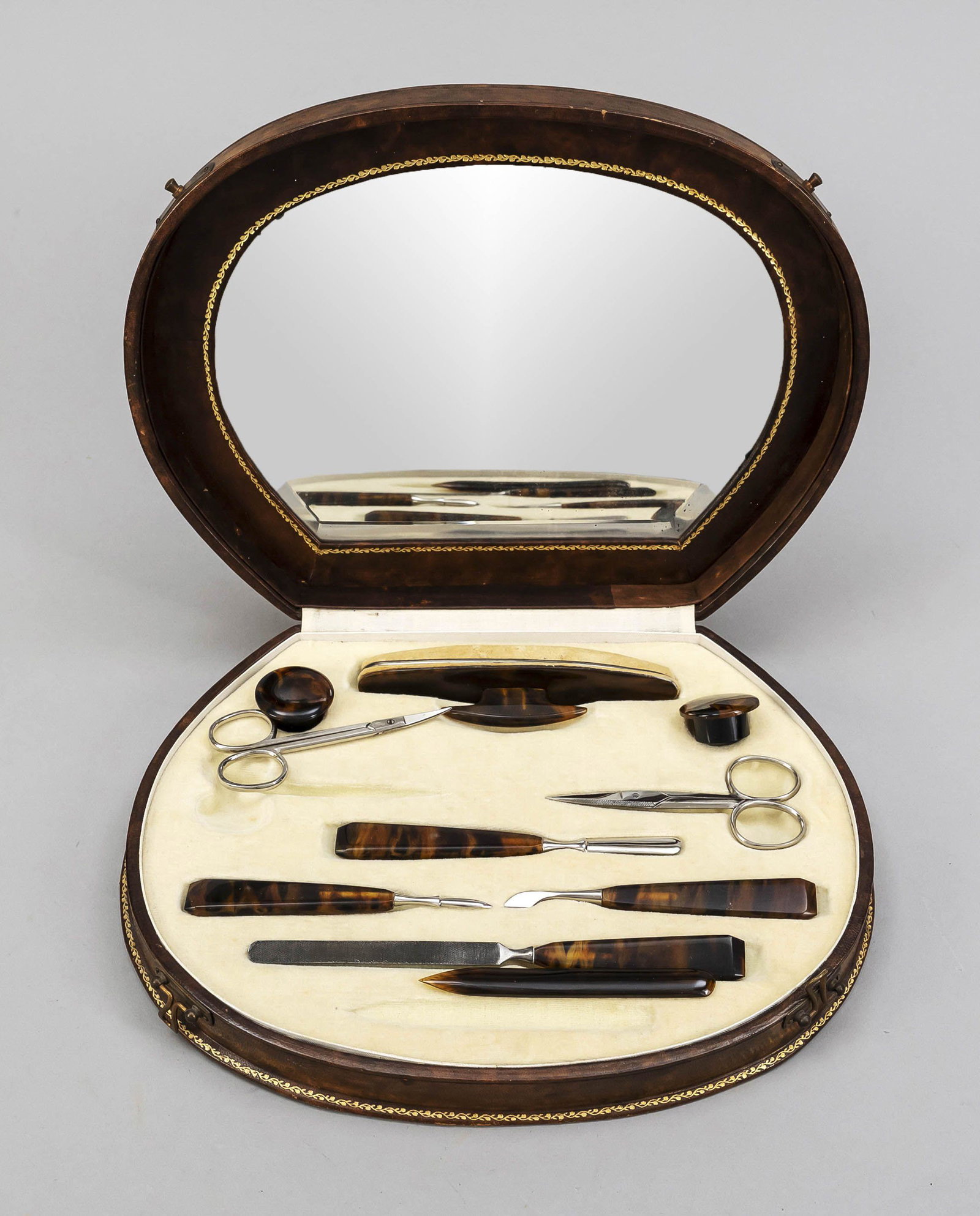 Manicure set, mid-20th century, wi: Manicure set, mid-20th century, with handles in tortoise shell look. In the lid of the case a mirror, 20 x 26 x 5 cm.