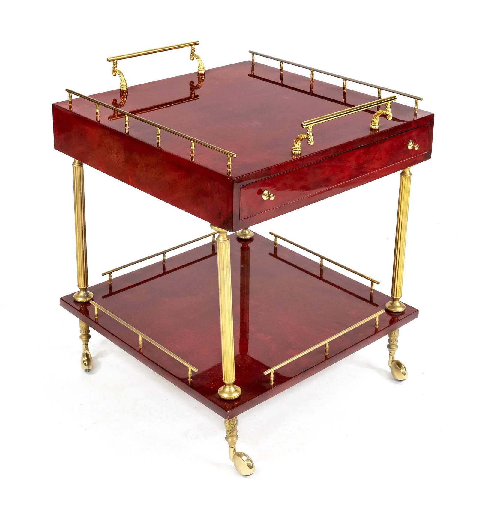 Mid-century serving trolley Aldo T: Mid-century serving trolley Aldo Tura, with red kidskin upholstery with lacquer coating. All parts in brass, 2 drawers, 2 shelves on casters, 76 x 63 x 60 cm.