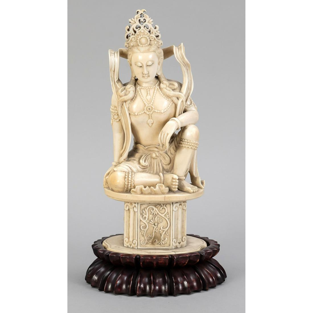 Buddhist figure of a saint, Ch: Buddhist figure of a saint, China, end of the 19th century, bone carving. Sitting with one bent leg on a pedestal with lotus tendril relief, openwork headdress. Placed on a plinth of dark hardwood. Fi